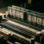 Κοντινό πλάνο σε modules μνήμης RAM πάνω σε μητρική πλακέτα με δραματικό φωτισμό που υποδηλώνει έλλειψη.